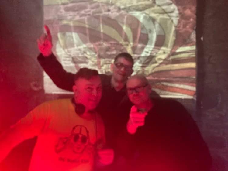 Friends together on the dance floor in deep red light