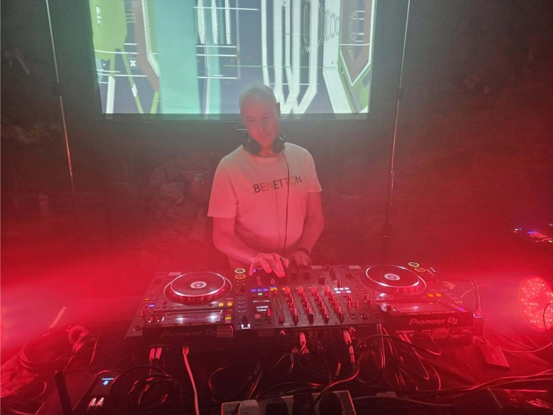 Paul Montague behind the decks in red light