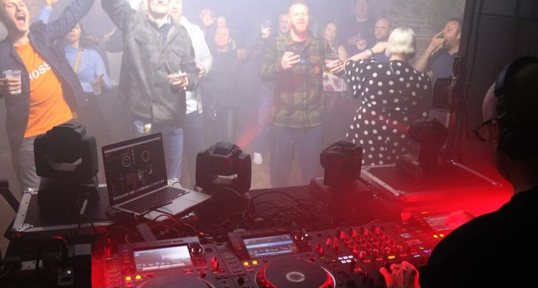 DJ silhouetted by fog and red light