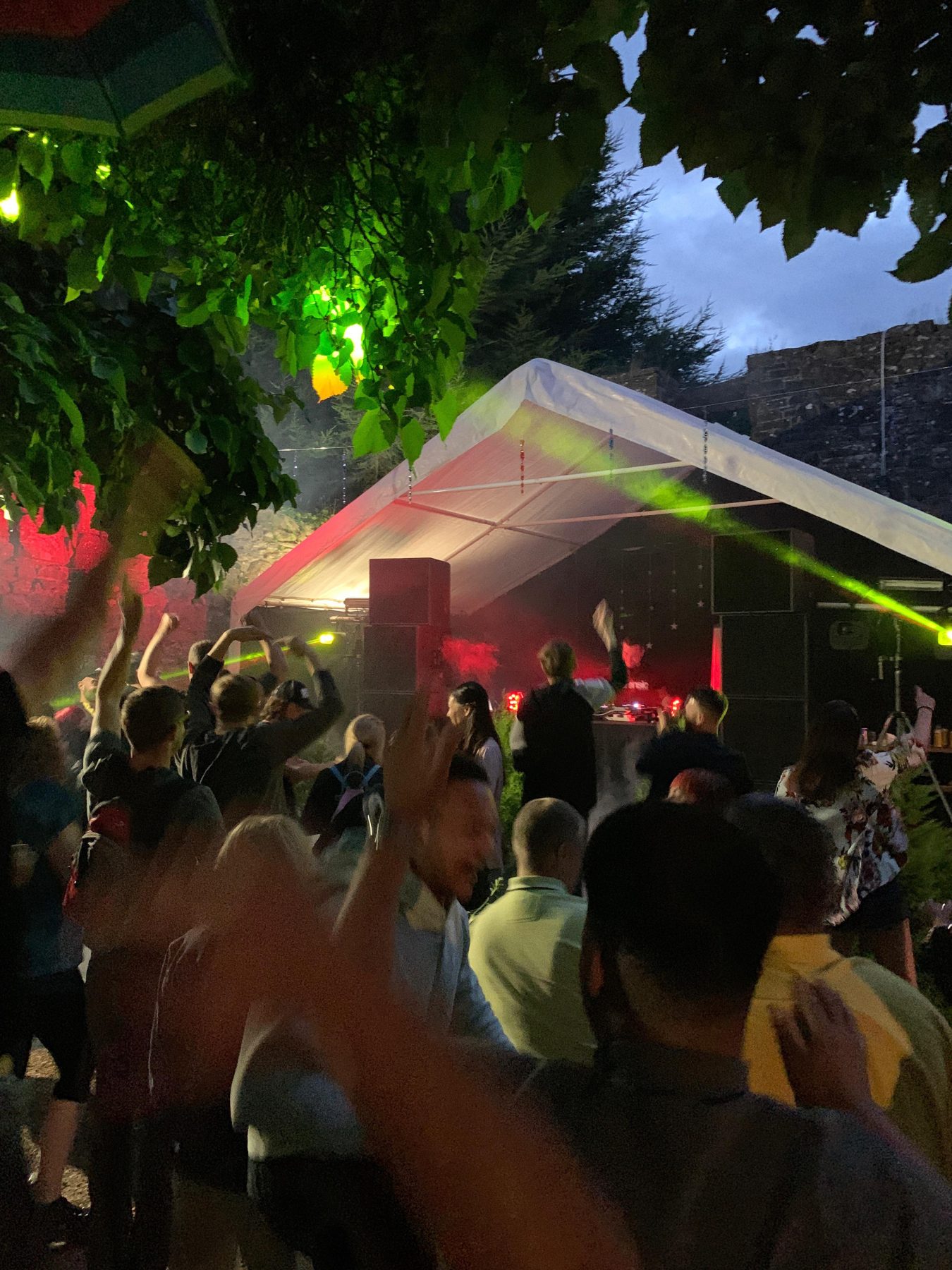 Dancers under lit trees in the castle grounds at night