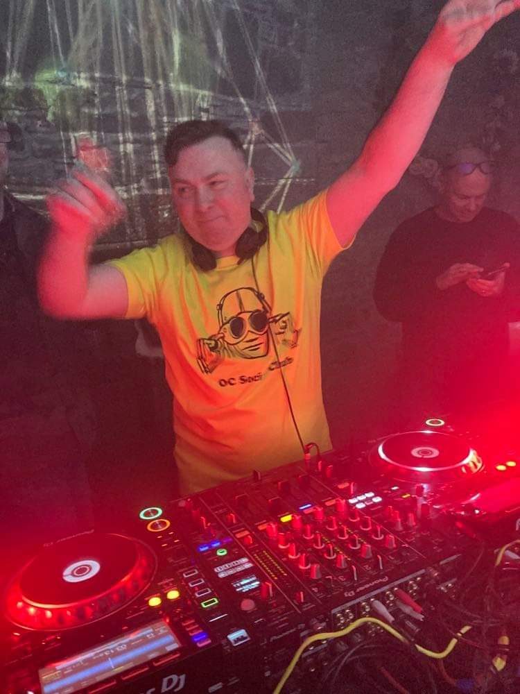 DJ throwing hands up behind the decks