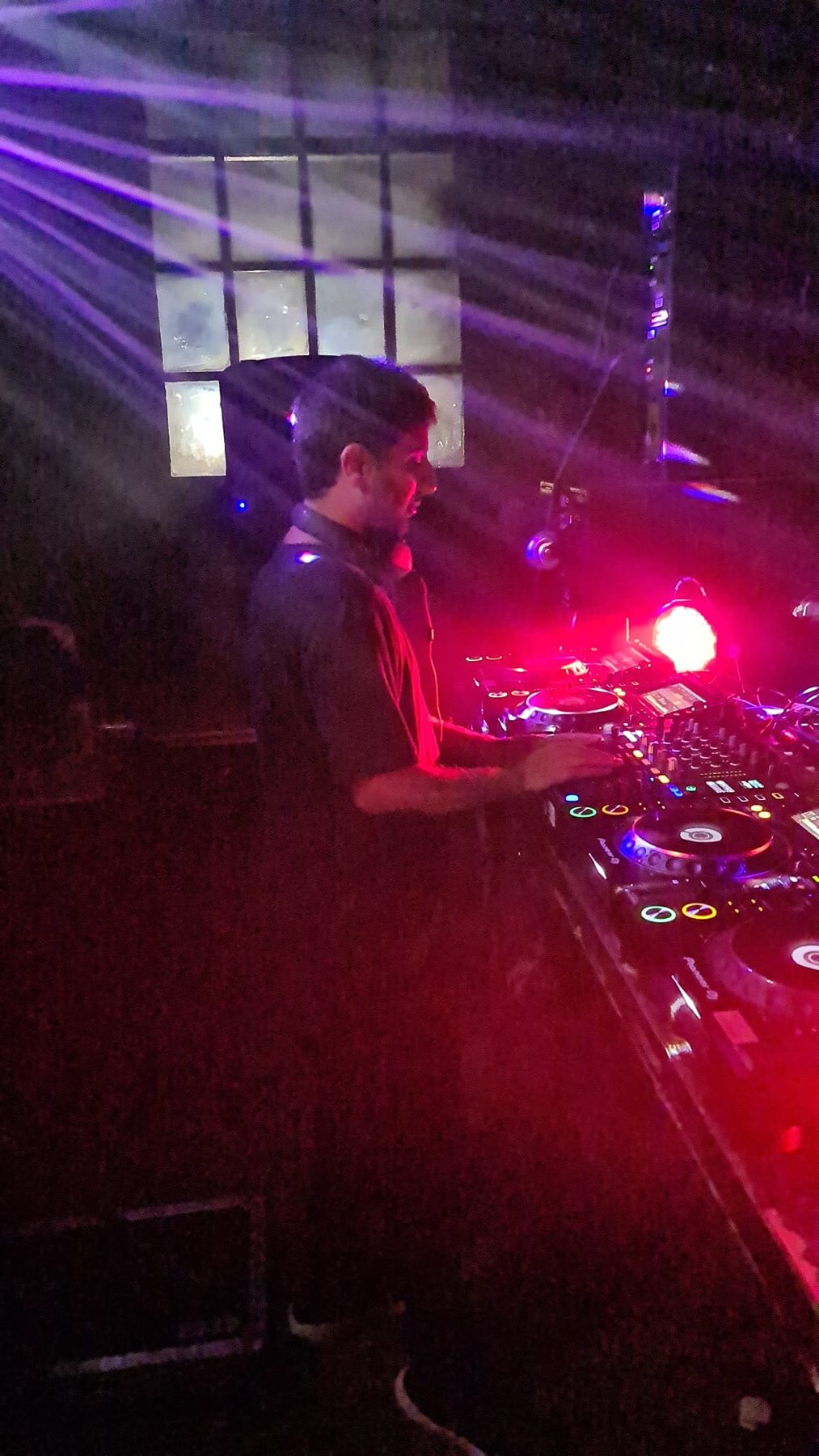 Red-lit DJ booth in full flow