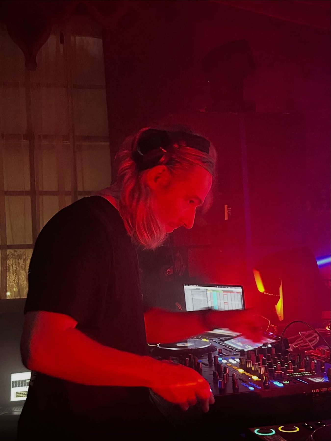 DJ mixing under deep red lighting