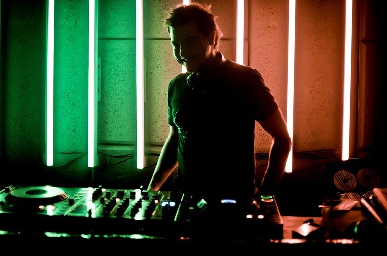 DJ playing under green wash lighting
