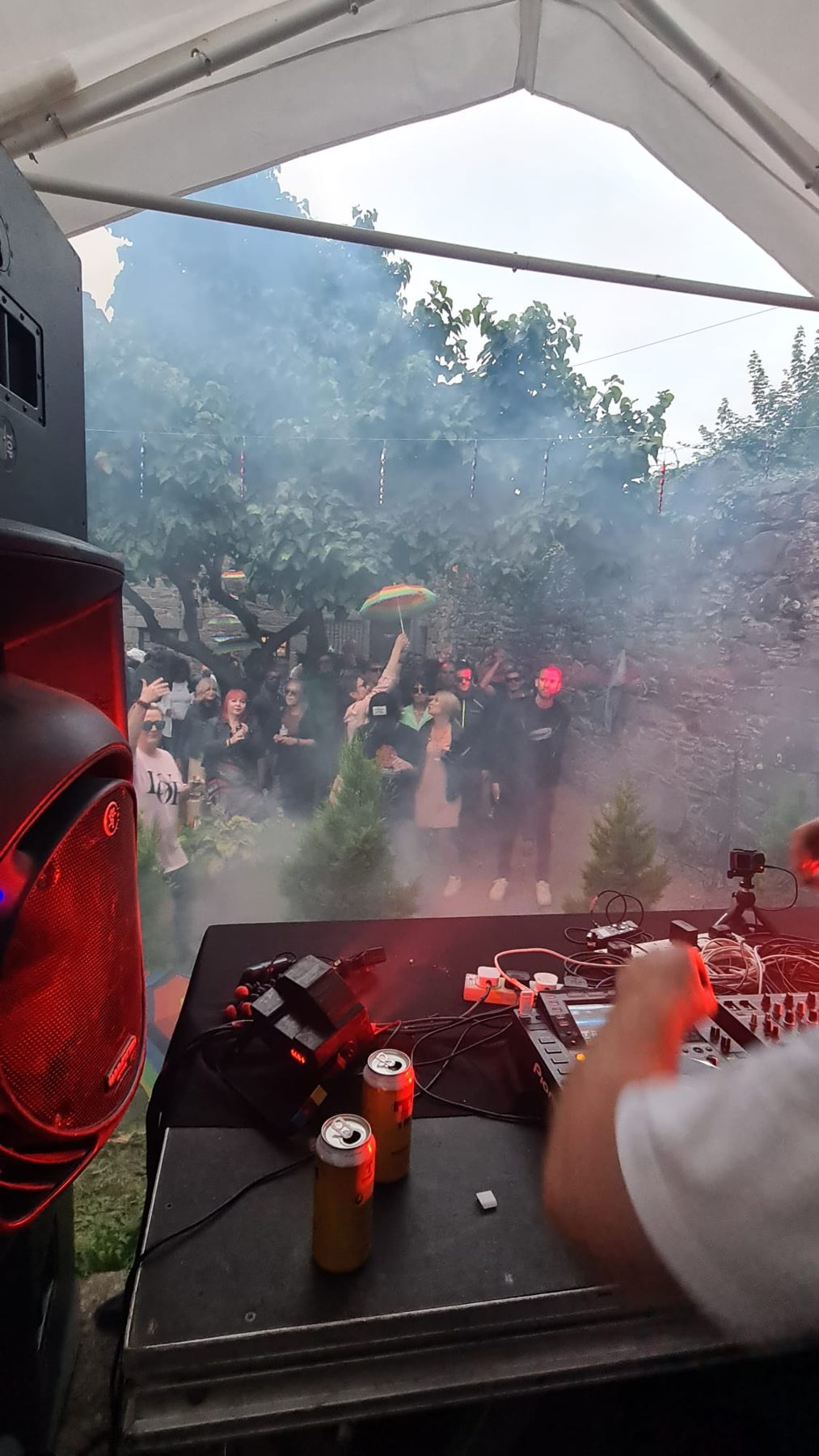 Packed marquee with smoke and lights during a daytime set